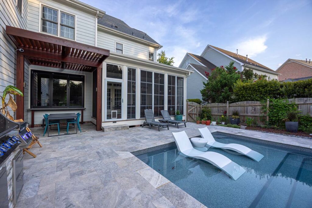 Exterior view of Dominion showing custom pool, pergola, and indoor deck.