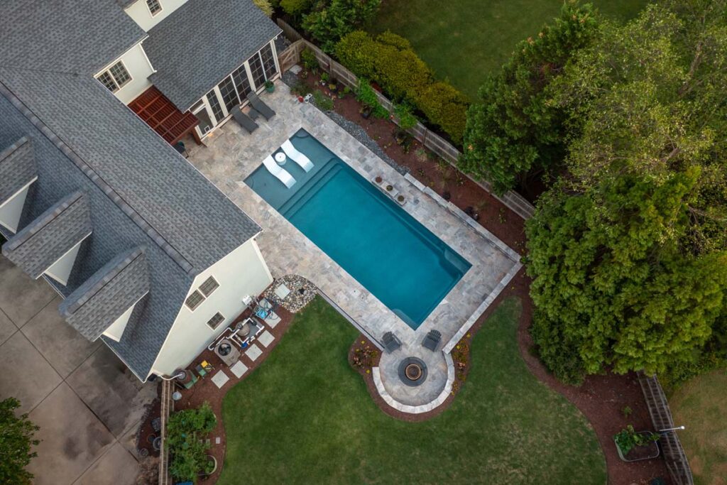 Aerial view of Dominion project showcasing custom fire pit, pergola, pool, and deck services.