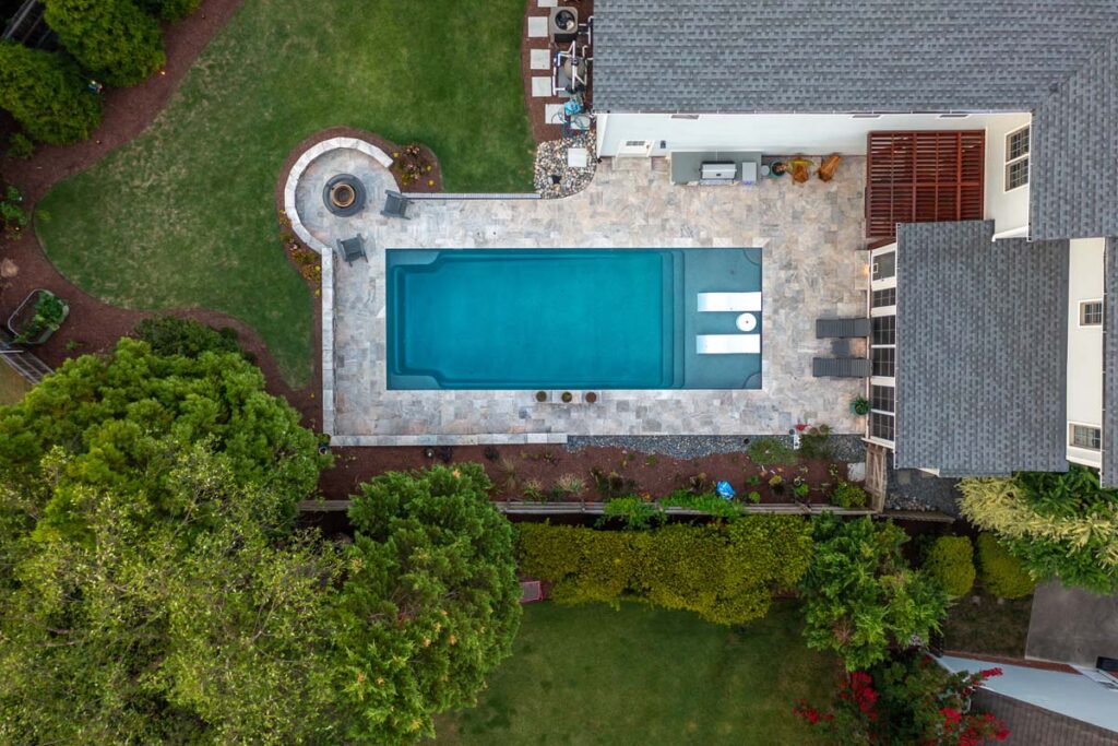 Aerial view of Dominion project showcasing custom fire pit, pergola, pool, outdoor grill, and deck services.