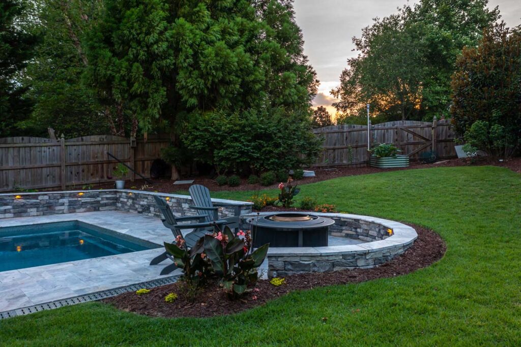 Ground level shot of Dominion fire pit with featuring pool drainage.