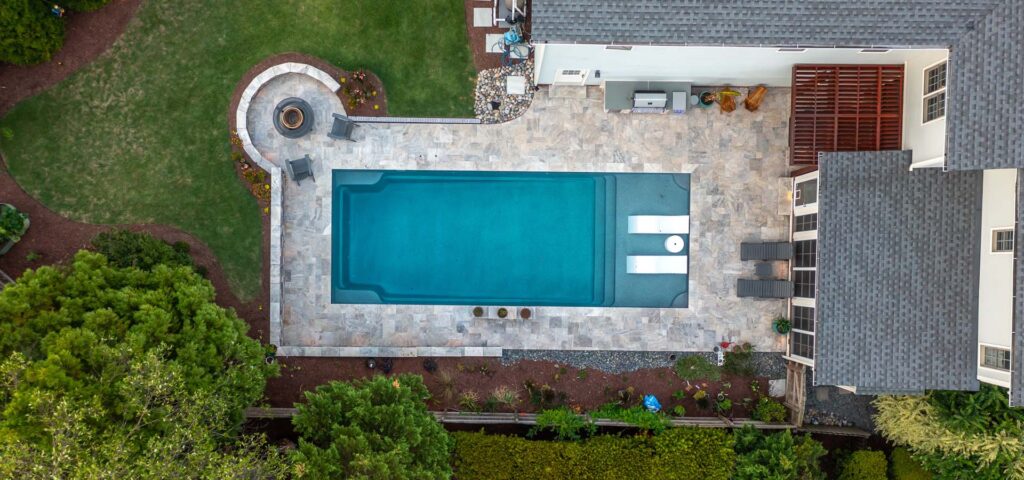Aerial view of Dominion project showcasing custom built fire pit, pool, outdoor grill and pergola.
